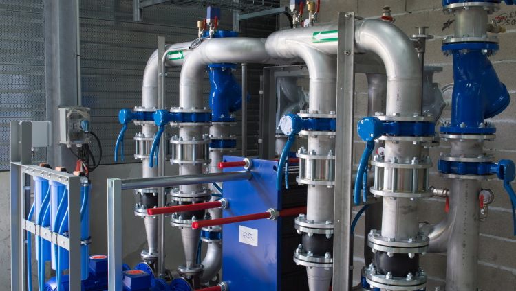 Process piping, valves and a plate heat exchanger in a plant room